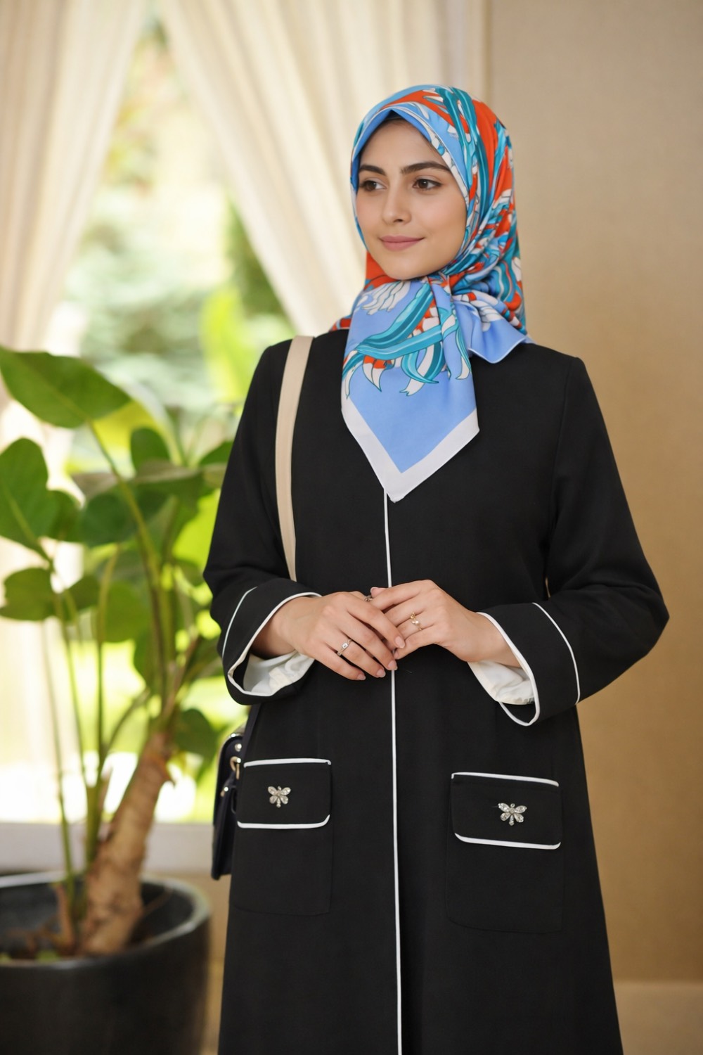 مانتو زنانه بلند مشکی ژاکارد از برند حوریان با مغزی‌دوزی کلاسیک ، طراحی پوشیده و شیک، مناسب استایل رسمی و روزمره